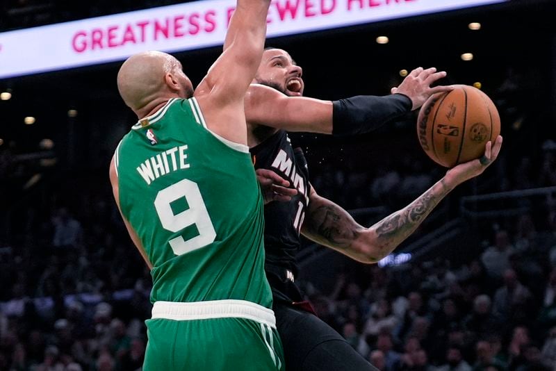Miami Heat forward Caleb Martin, right, drives to the basket against Boston Celtics guard Derrick White (9) during the second half of Game 2 of an NBA basketball first-round playoff series, Wednesday, April 24, 2024, in Boston. (AP Photo/Charles Krupa)