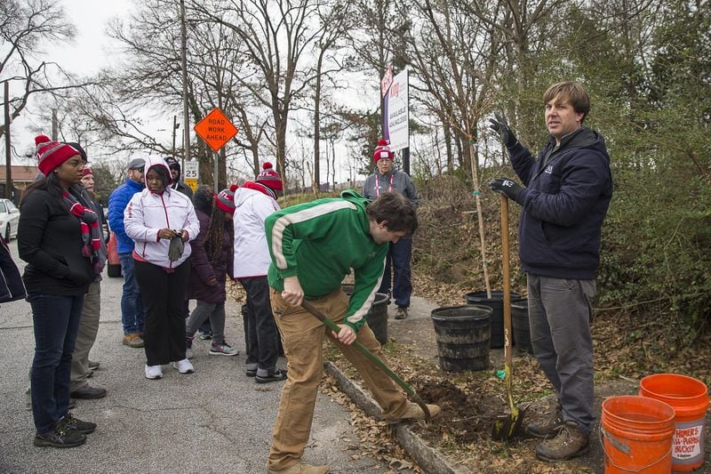 Dave Simpson (right), NeighborWoods manager of Trees Atlanta, speaks with volunteers Tuesday about how to plant their trees along English Avenue near the Salvation Army Bellwood Boys and Girls Club in Atlanta. (ALYSSA POINTER / ALYSSA.POINTER@AJC.COM)