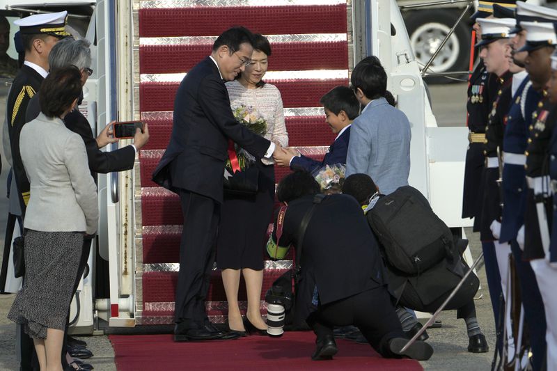 Prime Minister Fumio Kishida of Japan (center) and his wife Yuko Kishida, receive flowers after arriving at Andrews Air Force Base in Maryland on Monday.