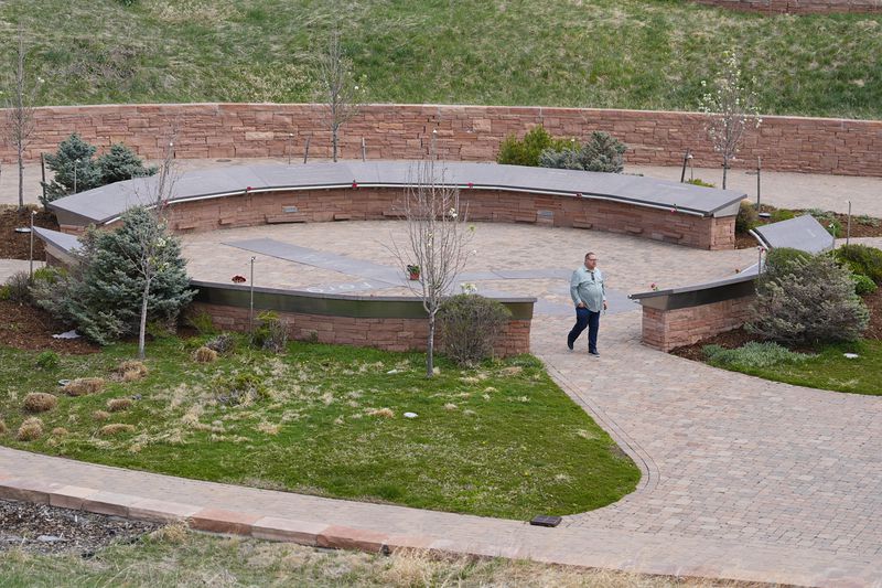 A visitor moves through the Columbine Memorial, Wednesday, April 17, 2024, in Littleton, Colo. Trauma still shadows the survivors of the horrific Columbine High School shooting as the attack's 25th anniversary approaches. (AP Photo/David Zalubowski)