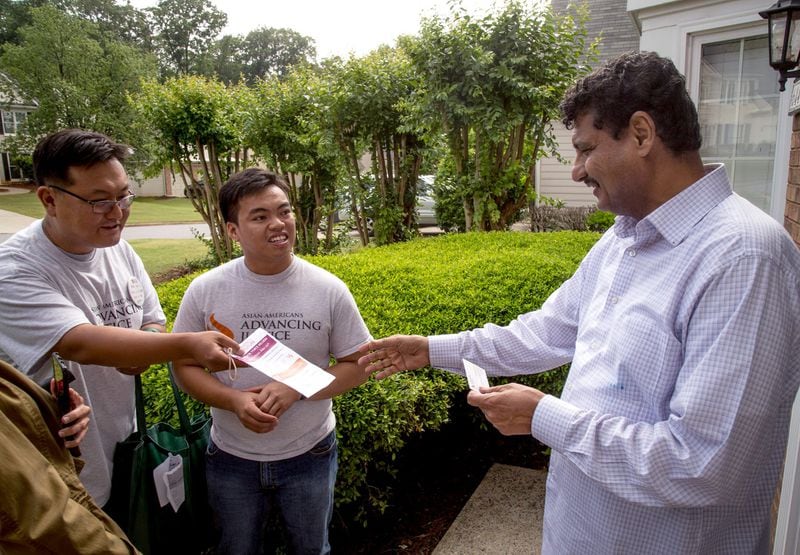 Volunteer Jongwon Lee (L) and Asian Americans Advancing Justice program associate Raymond Partolan (C) talked with Johns Creek homeowner Dr. Ahmed Baosman at his home last May. Partolan was under the protections of Obama-era immigration policies, which are being rescinded under President Donald Trump. STEVE SCHAEFER / SPECIAL TO THE AJC