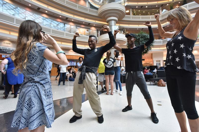 \Adrianna Worley, 11 (foreground), dances with performers from Atlanta Music and Dance Academy (from left) Leon Von Brown, Peter Gantt and Sally Stewart before they participate in a flash mob at Hartsfield-Jackson International Airport's domestic terminal atrium on Friday, Aug. 3, 2018. (Photo: HYOSUB SHIN / HSHIN@AJC.COM)