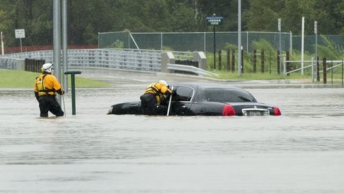 Rescuers search a flooded car on Park Row Drive adjacent to the Addicks Reservoir in west Houston after Hurricane Harvey on Tuesday August 29, 2017. JAY JANNER / AMERICAN-STATESMAN