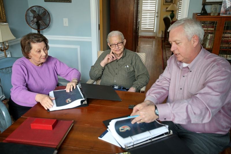 AJC editor Kevin Riley (right) sits down with WWII veteran Eddie Sessions (center) and his wife Shirley (left) as they look over new records documenting Sessions' service in WWII at their home.