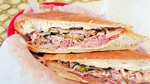 A cuban sandwich consisting fo ham roast pork swiss cheese and pickles on Cuban Bread from Havana Sandwich Shop