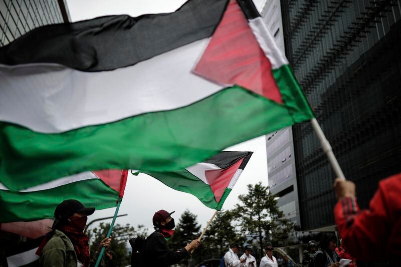FILE - Supporters wave Palestinian flags during a protest against the Israel-Hamas war, outside the Israel Embassy in Bogota, Colombia, Oct. 24, 2023. Israel said in October that it would halt security exports to Colombia after President Gustavo Petro refused to condemn Hamas’ Oct. 7 attack on southern Israel that triggered the war and compared Israel’s actions in Gaza to those of Nazi Germany. (AP Photo/Ivan Valencia, File)