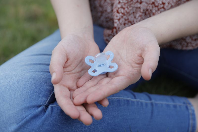A  21-year-old Columbus area woman holds her newborn’s  pacifier on Wednesday, June 7, 2023. After an unexpected pregnancy last year, she planned on getting an abortion but changed her mind and is now married with a  one month old son.  (Natrice Miller/natrice.miller@ajc.com)