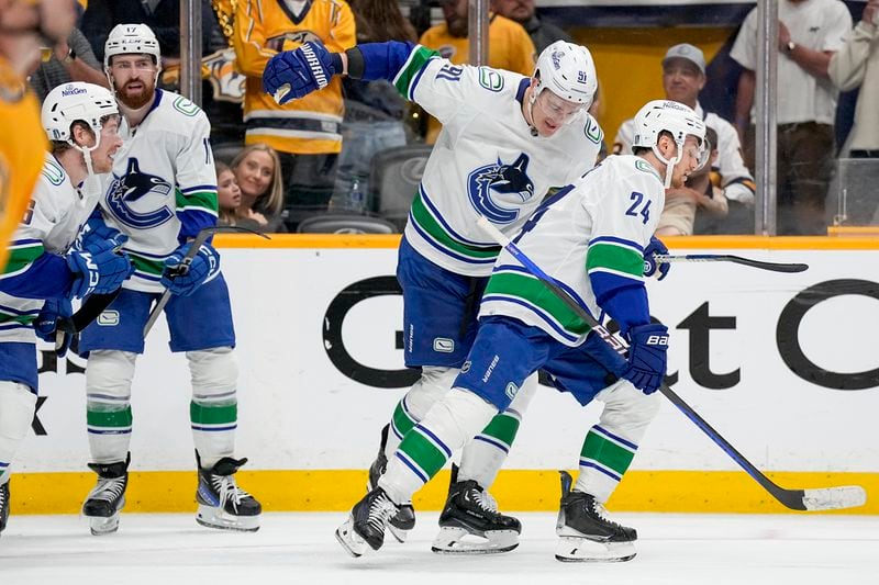 Vancouver Canucks defenseman Nikita Zadorov (91) congratulates center Pius Suter (24) after his goal against the Nashville Predators during the third period in Game 6 of an NHL hockey Stanley Cup first-round playoff series Friday, May 3, 2024, in Nashville, Tenn. The Canucks won 1-0 winning the series four games to two. (AP Photo/George Walker IV)