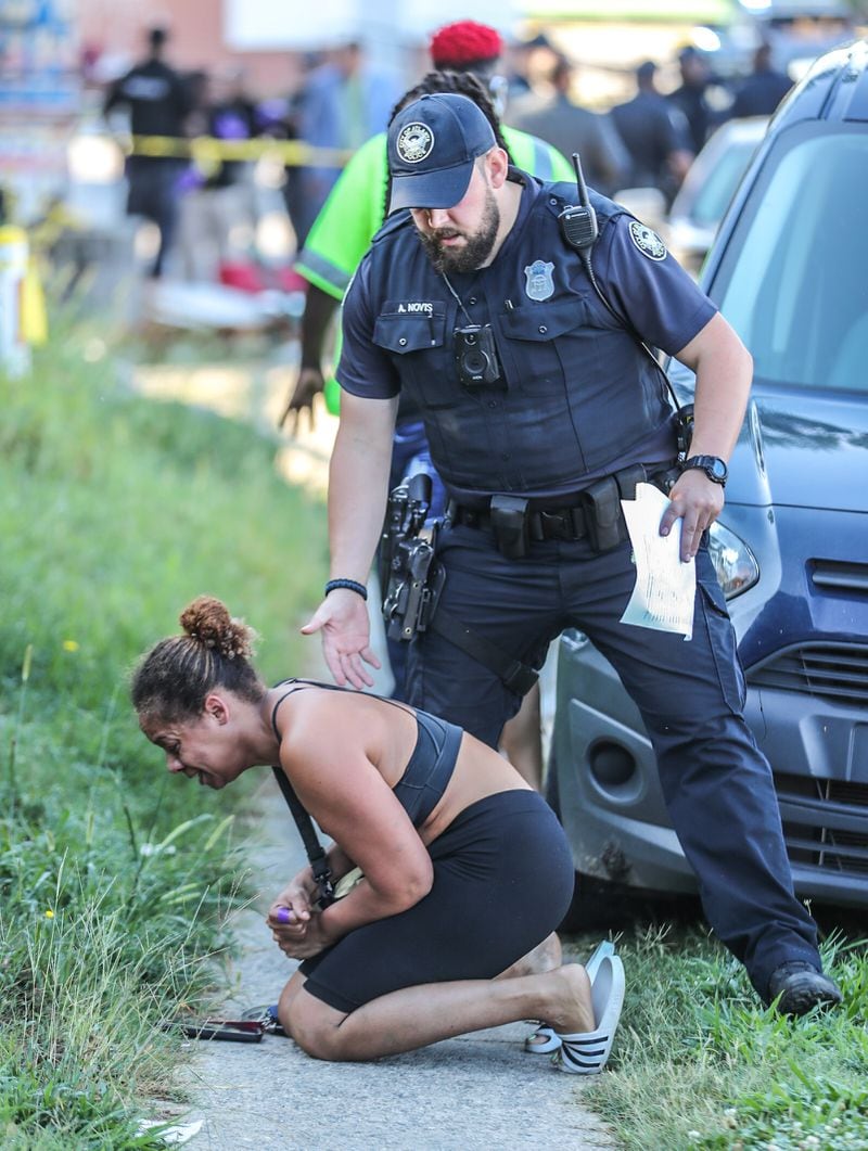 An officer tries to console a woman after Wednesday's shooting.