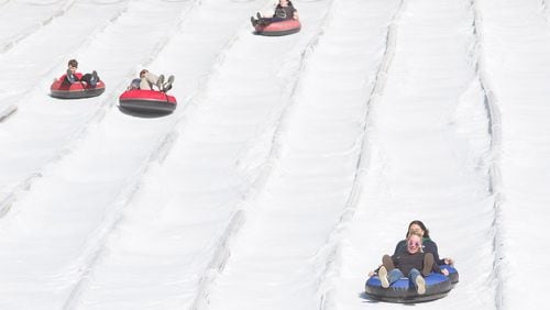 People head down the 400-foot tubing hill at Snow Mountain in Stone Mountain Park in this image from late November. Stone Mountain manufactures 360 tons of snow every day to accommodate the 400-foot tubing hill. STEVE SCHAEFER / SPECIAL