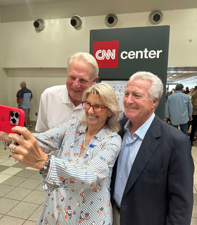 Teya Ryan (center) takes a selfies with fellow CNN alums Rick Davis (left) and Steve Korn (right) during the CNN legacy party June 1, 2023, to bid farewell to CNN Center. RODNEY HO/rho@ajc.com