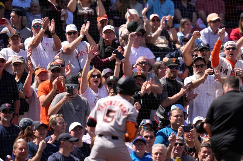 San Francisco Giants fans cheer after a solo home run by Mike Yastrzemski (5) during the third inning of a baseball game against the Boston Red Sox at Fenway Park, Thursday, May 2, 2024, in Boston. (AP Photo/Charles Krupa)