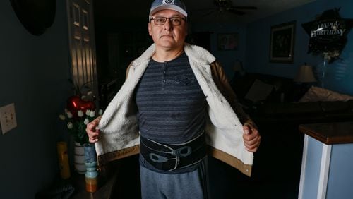 Jovito Caballero shows the back brace belt he wears all day to withstand back pain after an injury forced him to stop working. Caballero is currently involved in a legal dispute with Pilgrim’s Pride, the company he worked for over 20 years. Following a significant workplace injury, he was compelled to sign a document falsely disclaiming that the injury occurred on the job.
Miguel Martinez /miguel.martinezjimenez@ajc.com
