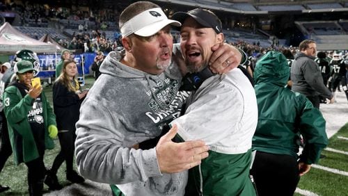 December 11, 2021 - Atlanta, Ga: Collins Hill head coach Lenny Gregory, left, celebrates with defensive coordinator Drew Swick in the closing minute of their 24-8 win against Milton in the Class 7A state title football game at Georgia State Center Parc Stadium Saturday, December 11, 2021, Atlanta. JASON GETZ FOR THE ATLANTA JOURNAL-CONSTITUTION