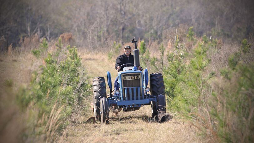 Cleveland Whitehead works on his tractor on his Flint River Farms property near Montezuma. 
Courtesy of Eric Dusenbery