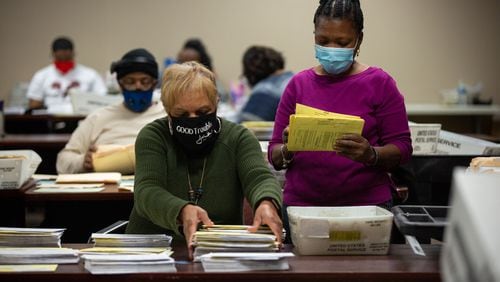 People sort absentee ballots at the DeKalb County Elections Office in Decatur, Georgia, on Wednesday, January 6, 2021. (Rebecca Wright for the Atlanta Journal-Constitution)