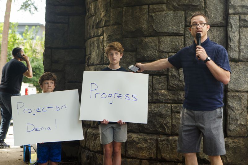 Charlie Copp (right), an educator in Atlanta Public Schools, speaks during a back-to-school rally for Georgia educators accompanied by his sons Charles Baxter Copp (left) and James Bennett Copp (center) on Saturday, July 23, 2022, at Piedmont Park in Atlanta. Teachers, community members and students gathered to speak against new state laws that limit classroom discussions about race and streamline the process for banning books in schools. (Christina Matacotta for The Atlanta Journal-Constitution) 