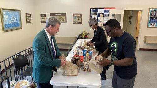 Republican U.S. Rep. Buddy Carter of Pooler, left, helps distribute food at the Old Savannah City Mission. (Photo provided by Carter’s office.)