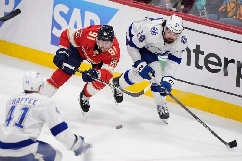 Florida Panthers defenseman Oliver Ekman-Larsson (91) battles for the puck with Tampa Bay Lightning left wing Nicholas Paul (20) and right wing Mitchell Chaffee (41) during the third period of Game 1 of the first-round of an NHL Stanley Cup Playoff series, Sunday, April 21, 2024, in Sunrise, Fla. (AP Photo/Wilfredo Lee)