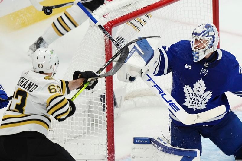 Toronto Maple Leafs goaltender Ilya Samsonov, right, makes a save as Boston Bruins' Brad Marchand (63) looks for a rebound during second-period action in Game 4 of an NHL hockey Stanley Cup first-round playoff series in Toronto, Saturday, April 27, 2024. (Nathan Denette/The Canadian Press via AP)