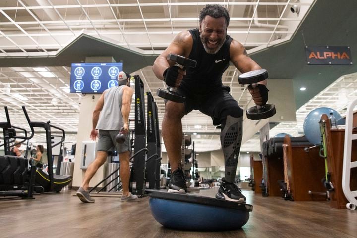 Tiran Jackson balances on a ball with weights at Life Time Woodstock on Wednesday, July 6, 2022, in Woodstock, Georgia. Jackson said fitness is important to him to ensure he can continue to walk and maintain his balance with his leg and prosthetic. (Chris Day/Christopher.Day@ajc.com)