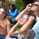 Elizabeth Massey, right, watches the eclipse with her children Henry, 9, front, and Laynee, 12, at the Northgate branch of the Chattanooga Public Library on Monday. (Photo Courtesy of Matt Hamilton)