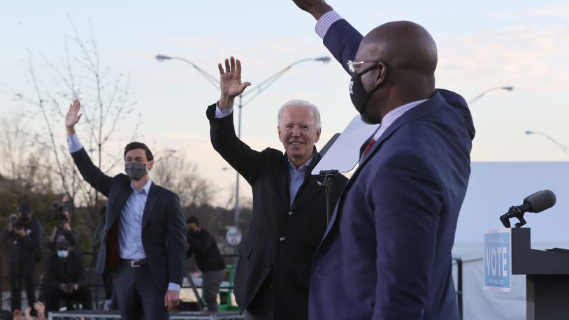 President-elect Joe Biden, middle, along with Democratic candidates for the U.S. Senate Jon Ossoff, left, and Rev. Raphael Warnock, greet supporters during a campaign rally in the parking lot of Centerparc Stadium on January 4, 2021, in Atlanta. (Chip Somodevilla/Getty Images/TNS)