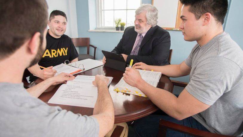 Chase Keith (back to camera), a student in the Veterans Legal Clinic, and Andy Bastone (second from left) and Nick Mugge (right) discuss the clinic with director Alex Scherr, offering their perspectives as the first three veterans to receive scholarships to UGA’s School of Law. CONTRIBUTED BY UNIVERSITY OF GEORGIA SCHOOL OF LAW