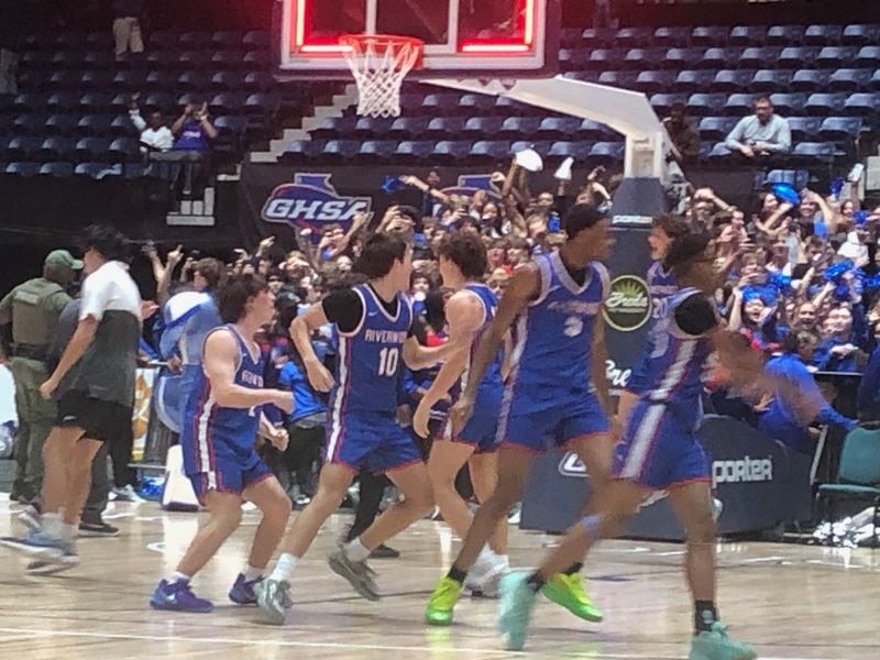 The Riverwood basketball team storms the court after beating Alexander 67-63 in OT in the Class 6A championship game, March 8, 2024, at the Macon Coliseum.
