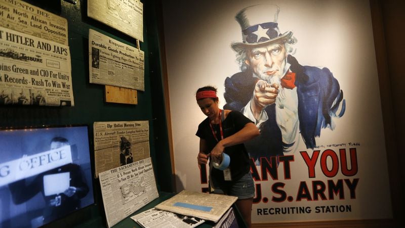 Kristin Guillot works on installing images of newspapers as part of the permanent exhibit "Salute to the Home Front" at the National World War II Museum which will open to the public this Saturday, in New Orleans, Monday, June 5, 2017. The exhibit tells the home front story from the 1920s to the development of the atomic bomb. (AP Photo/Gerald Herbert)