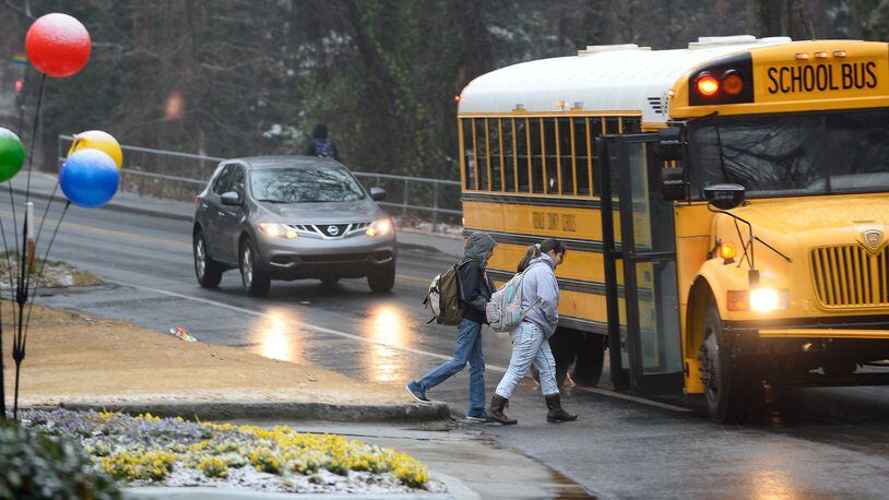 DeKalb County students board a bus during a wintry mix of snow, sleet and rain, Tuesday, Feb. 24, 2015, in Atlanta. The University of Georgia's Gwinnett campus delayed their opening while further west, the Cobb County school system canceled classes and weather forecasters predicted another round of winter weather for Wednesday. (AP Photo/David Tulis)
