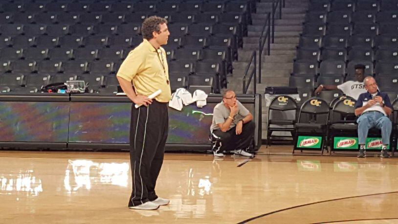 Ron Bell, kneeling in the background, observes a Georgia Tech basketball practice run by head coach Josh Pastner, foreground. Bell and his girlfriend attended practices, ate meals with the team, visited the locker room, and at least once rode the team bus. Photo courtesy of Ron Bell.