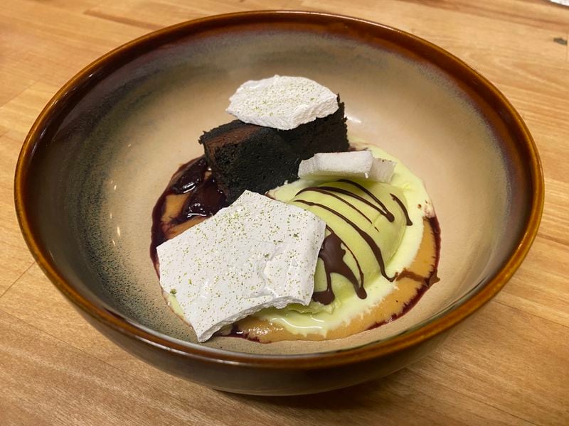 A recent meal at Bovino After Dark featured a dessert of fermented black bean cake with mint ice cream, rum-soaked cherries, dulce de leche sauce and meringue bark. Ligaya Figueras/lfigueras@ajc.com