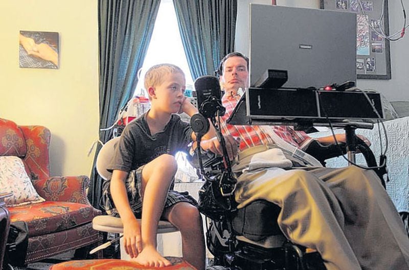David Jayne home-schools his stepson, Rickie Geyer, 10, each weekday morning. Jayne and two of his stepchildren have written and released an illustrated children’s book, “Bubblegum Blues.” Jayne maneuvers his chair with small device attached to his cheek.