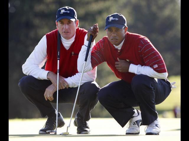 Tiger Woods and Jim Furyk discuss a putt during the Presidents Cup foursome matches, Montreal, Canada, in September of 2007.