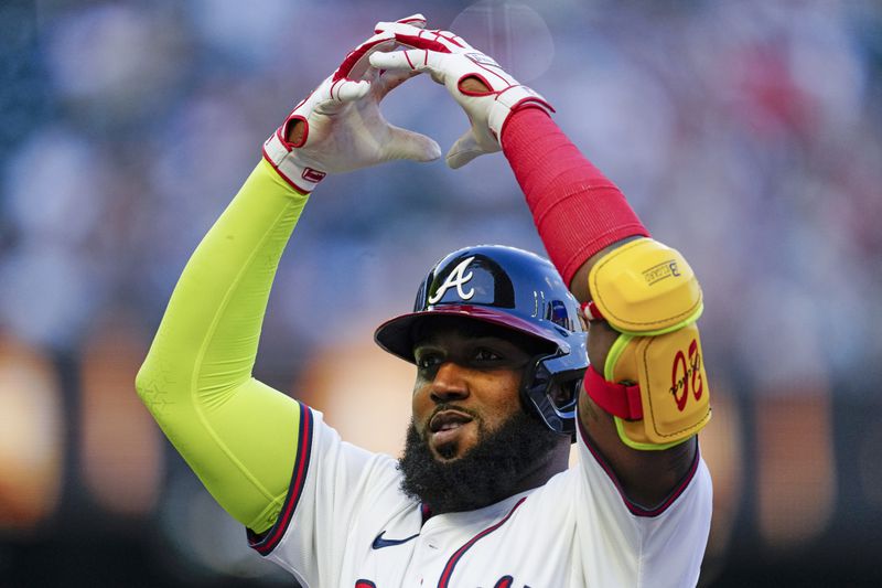 Atlanta Braves designated hitter Marcell Ozuna gestures to his teammates in the dugout after driving in a run with a single in the first inning of a baseball game against the Miami Marlins Wednesday, April 24, 2024, in Atlanta. (AP Photo/John Bazemore)