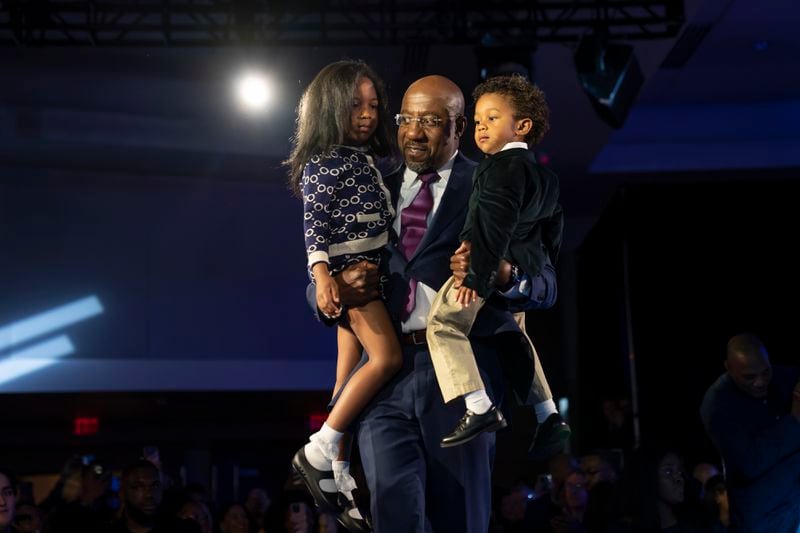 Sen. Raphael Warnock (D-Ga.) takes the stage with his children Chloe, left, and Caleb as he celebrates his re-election victory in the runoff election against his Republican challenger, Herschel Walker, in Atlanta on Tuesday night, Dec. 6, 2022.  (Nicole Craine/The New York Times)