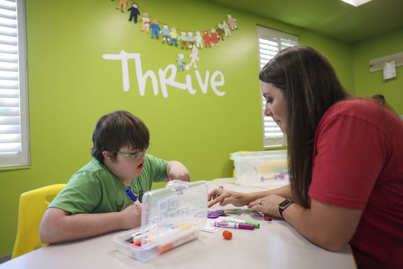 Noah Cole works with volunteer Kayla Cox, right, as they create art in the special needs ministry Thrive Special Needs Ministry at First Baptist Church Woodstock, Wednesday, March 20, 2024, in Woodstock, Ga. (Jason Getz / jason.getz@ajc.com)