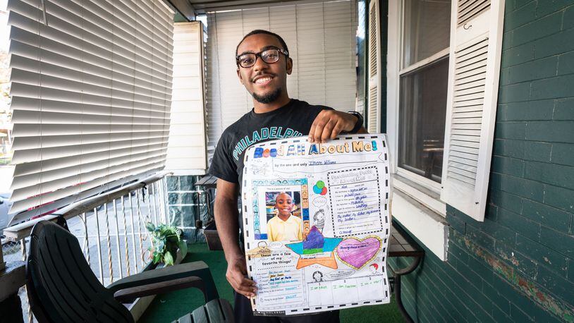 West Chester student Imere Williams, holding a class assignment of his from fourth grade when he wrote that he wanted to be a teacher, at his home in Philadelphia.