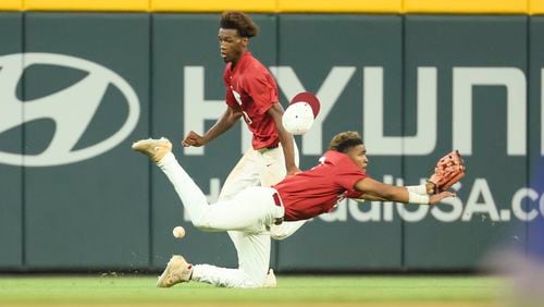 Lowndes outfielders Jordan Hudson, center diving, and Qrey Lott cannot make the catch on a ball hit by Parkview’s Makhi Buckley (not pictured) during the sixth inning in game one of the GHSA baseball 7A state championship at Truist Park, Tuesday, May 16, 2023, in Atlanta. It was determined Buckley was out at third base and the scoring run on the play did not count. Lowndes won 3-2. (Jason Getz / Jason.Getz@ajc.com)