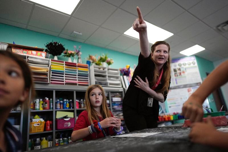 Ella Oliveri, 8, center left, gets guidance from teacher Lindsey Wuest, as students make clay models of endangered or vulnerable animal species, in Wuest's Science As Art class at A.D. Henderson School in Boca Raton, Fla., Tuesday, April 16, 2024. When teachers at the K-8 public school, one of the top-performing schools in Florida, are asked how they succeed, one answer is universal: They have autonomy. (AP Photo/Rebecca Blackwell)