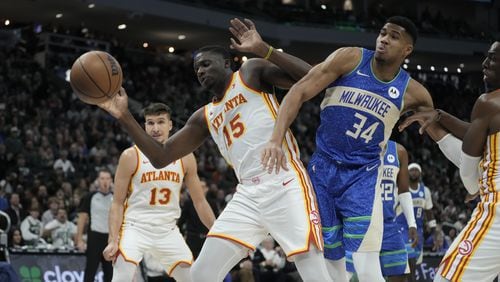 Giannis Antetokounmpo of the Bucks battles Hawks centers Clint Capela (left) and Onyeka Okongwu (right) for a loose ball during the second half of an NBA basketball game Saturday, Dec. 2, 2023, in Milwaukee. The Bucks won 132-121. (AP Photo/Morry Gash)