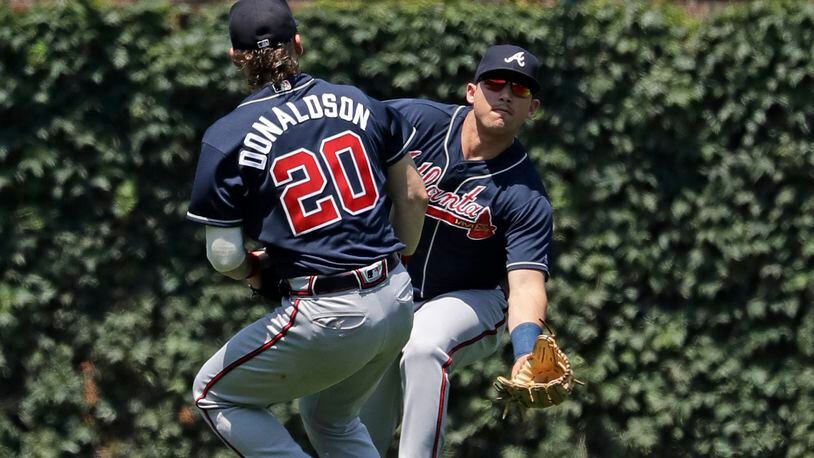 Atlanta Braves left fielder Austin Riley, right, can't make the play on a single by Chicago Cubs' Anthony Rizzo as third baseman Josh Donaldson (20) watches on during the first inning of a baseball game in Chicago, Thursday, June 27, 2019. (AP Photo/Nam Y. Huh)