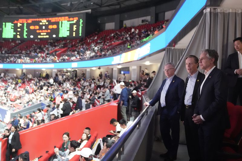 U.S. Secretary of State Antony Blinken talks with U.S. Ambassador to China Nicholas Burns, center, with U.S. Consulate General in Shanghai Scott Walker, left, while attending a basketball game between the Shanghai Sharks and the Zhejiang Golden Bulls at the Shanghai Indoor Stadium, Wednesday, April 24, 2024, in Shanghai, China. (AP Photo/Mark Schiefelbein, Pool)