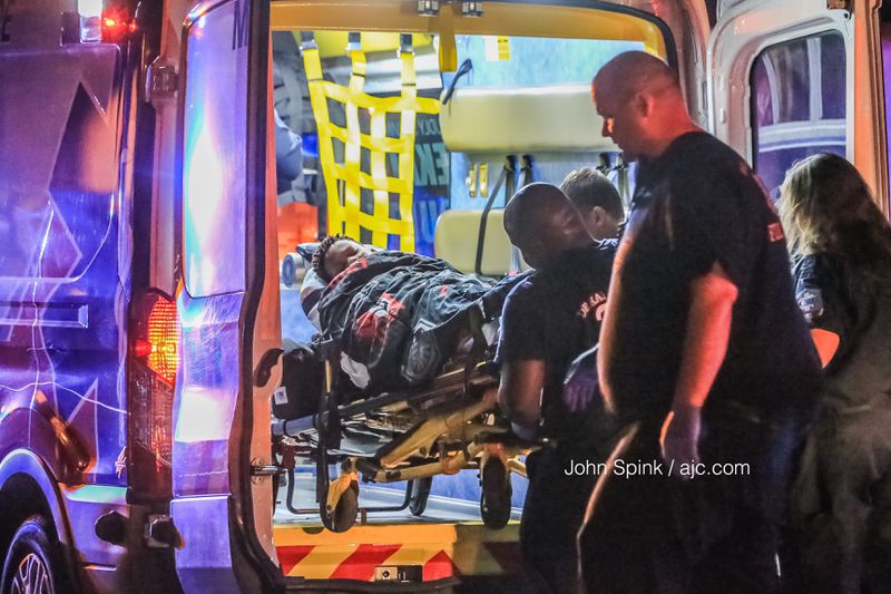 A child is loaded into the back of an ambulance after an early Monday morning shooting in the 3100 block of Citrus Court in DeKalb County. JOHN SPINK / JSPINK@AJC.COM