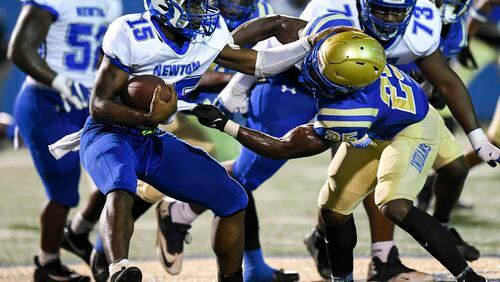 Newton’s Rontravious Perry (15) is tackled by McEachern offensive linebacker Rene’ Barber III (25) in the first half of play at McEachern High School Friday, Sept. 17, 2021. (Daniel Varnado/For the AJC)