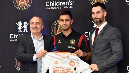 Atlanta United's newest signing, Pity Martinez (center), poses with team president Darren Eales (left) and Carlos Bocanegra (right) on Friday at the team's training ground in Marietta. (Hyosub Shin / AJC)
