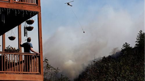 A helicopter works dropping water on the Rock Mountain Fire as it approaches homes on Wednesday, Nov. 16, 2016, in Tate City. Curtis Compton/ccompton@ajc.com