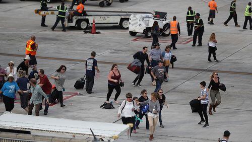 FORT LAUDERDALE, FL - JANUARY 06: People seek cover on the tarmac of Fort Lauderdale-Hollywood International airport after a shooting took place near the baggage claim on January 6, 2017 in Fort Lauderdale, Florida.