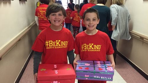 Liberty Elementary second graders Chase Walsh (left) and Brandon Holstein participate in a service project that delivered 100 boxes of Valentine wishes to residents of a senior center in Canton. The school was recently nationally recognized for its character education program.